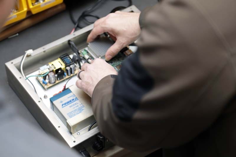 A control panel being wired and assembled by hand
